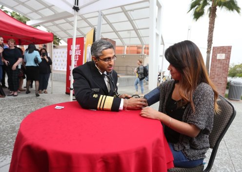 U.S. Surgeon General Vivek Murthy provides a heart health screening for a student at Cal State LA.